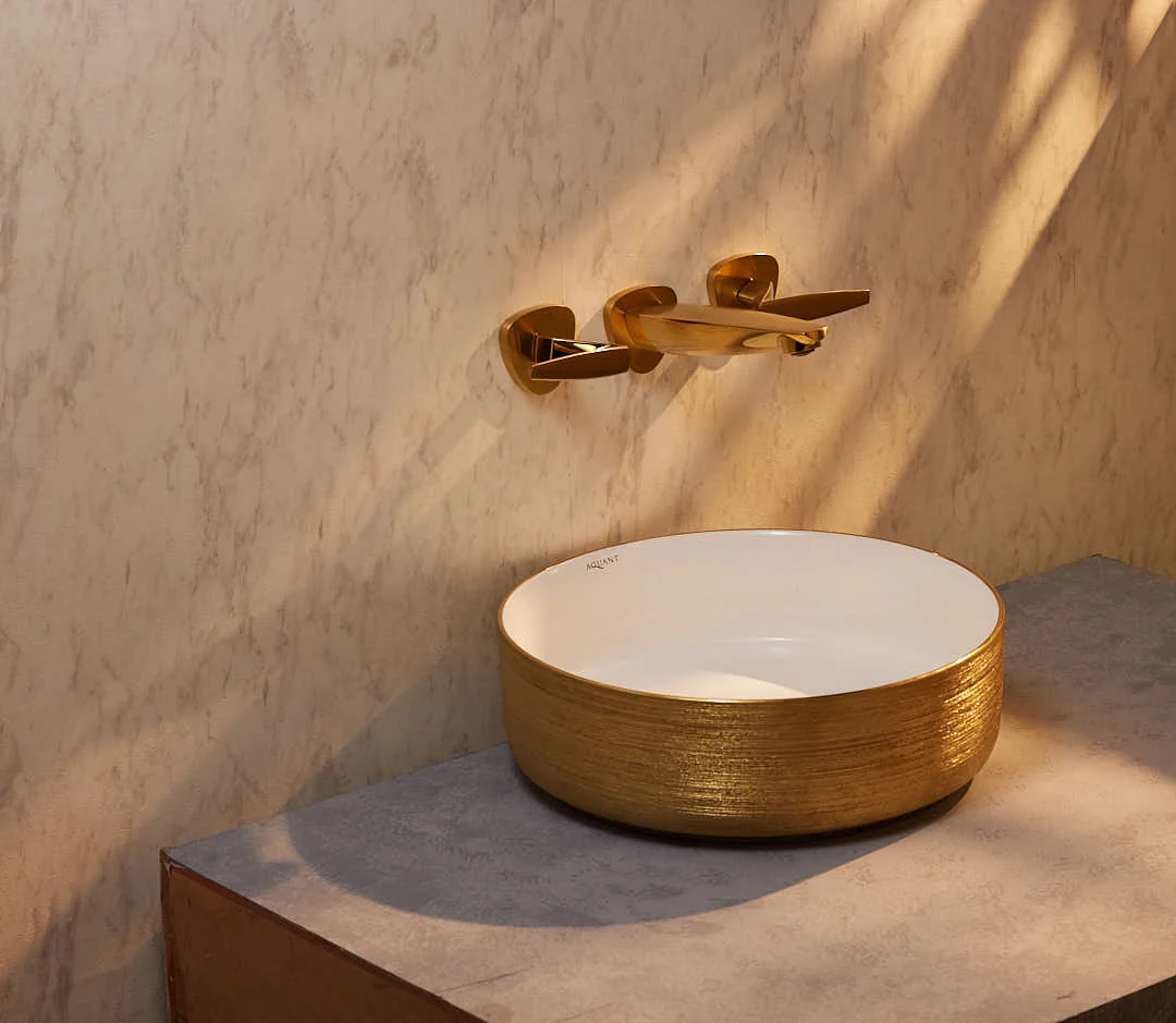 Travertine bathroom with warm wood vanity and arched mirror